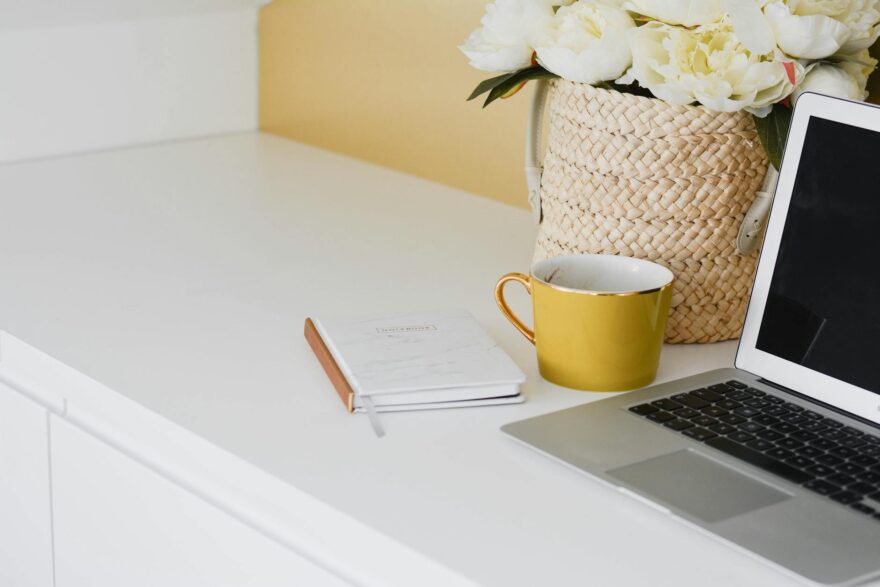 yellow mug besides laptop