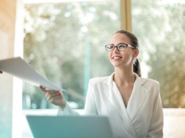 positive businesswoman doing paperwork in office